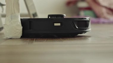 Yuvarlak robot süpürgesi banyoda düzenli olarak hareket ediyor, sensörleri toz ve saç taraması yapıyor. Yüksek kalite 4k görüntü