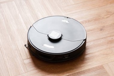 Robot elektrikli süpürge daireyi belli bir zamanda otomatik olarak temizliyor. Akıllı ev. Yüksek kalite fotoğraf