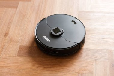 Robot elektrikli süpürge daireyi belli bir zamanda otomatik olarak temizliyor. Akıllı ev. Yüksek kalite fotoğraf