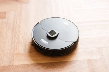 Robot elektrikli süpürge daireyi belli bir zamanda otomatik olarak temizliyor. Akıllı ev. Yüksek kalite fotoğraf