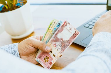 Bir adamın elini kapat ve parayı say Katar parası. Yüksek kalite fotoğraf