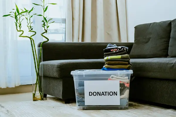 İçinde kıyafet ve ayakkabı olan bağış kutuları dairedeki kanepeye karşı. Yüksek kalite fotoğraf