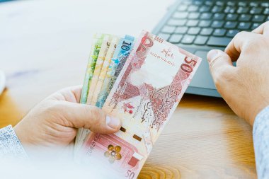 Bir adamın elini kapat ve parayı say Katar parası. Yüksek kalite fotoğraf