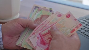 Özbekistan Ulusal Para Birimi Som 'da Özbek toplam banknotlarını sayan bir adamın yakın çekimi. Yüksek kalite 4k görüntü