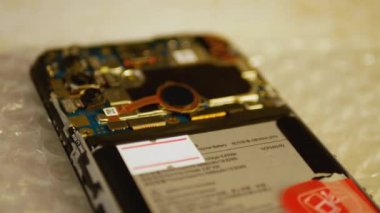 Mühendis cep telefonunu tamir ediyor. Akıllı telefona parmak izi sensörü takıyorum. Akıllı telefon tamir konsepti. Yakın çekim görüntüsü. 4K