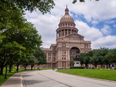 Lone Star State 'in zengin tarihini ve vatansever gururunu Teksas Eyalet Kongre Binası' nın bu çarpıcı fotoğrafıyla kutlayın. Güneşli bir yaz gününün arka planında, Amerikan ve Teksas bayrakları rüzgarda gururla dalgalanıyor.