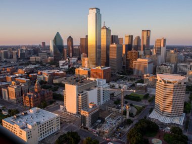 Bu çarpıcı fotoğrafta çekilen canlı Dallas siluetinin tadını çıkarın. Altın güneş şehri hayata döndüren sıcak ve davetkar bir ortam yaratırken Dallas Adliyesi 'nin simgesi olan adliye sarayı da en alt köşede görkemli bir şekilde duruyor. Bu...
