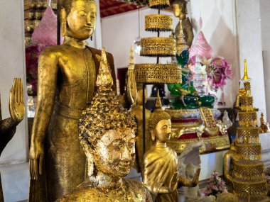 Altın Buda heykellerinin ilahi güzelliğini tecrübe edin, Tayland, Bangkok 'taki Wat Arun Tapınağı' nın kutsal salonlarını aydınlatın. Karmaşık detaylar ve çarpıcı ustalıkla bu fotoğraf Budist kültürünün özünü ve özünü yansıtıyor.