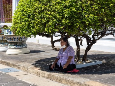 Tayland, Bangkok 'ta sıcak ve nemli hava yerel halk için bile zor olabilir. Taylandlı bir kadın Wat Arun Tapınağı 'ndaki bir ağacın altında dinleniyor..