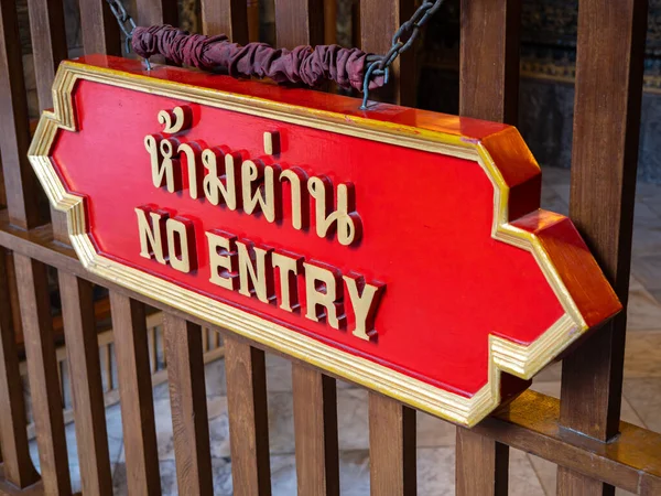 A red sign with the words NO ENTRY in both Thai and English is seen up close at the Wat Pho temple in Bangkok, Thailand.