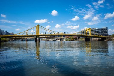 Pittsburgh, Pennsylvania 'daki Allegheny Nehri' nin üzerinde bulutlu mavi bir gökyüzü. Sarı Rachel Carson Köprüsü manzaralı..