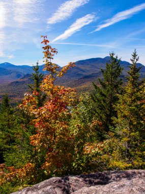 New York eyaletindeki Adirondack Dağları 'nın nefes kesen güzelliği. Manzara, çarpıcı bir gökyüzünün arka planına karşı sonbahar renklerinin canlı renkleriyle canlanıyor..