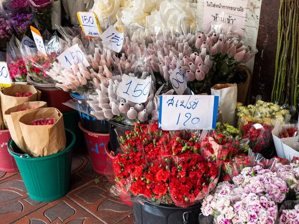 Fiyat etiketleriyle süslenmiş çeşitli çiçek çeşitleri müşterileri Bangkok, Tayland 'ın hareketli çiçek pazarına çağırıyor..