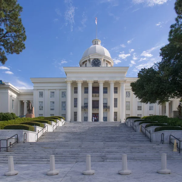 Montgomery, Alabama, ABD 'deki görkemli Alabama Eyalet Meclisi, küçük beyaz bulutlarla süslenmiş açık mavi gökyüzünün bir zeminine uzanır..