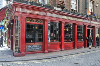 Londra, İngiltere - 8 Temmuz 2008: Londra 'nın göbeğinde, canlı kırmızı ahşap aksanlı ve caddeye bakan birçok pencereli klasik bir İngiliz barı duruyor.