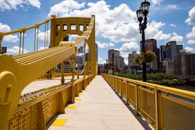 Sunny Pittsburgh: Mavi gökyüzü & şehir merkezinin üzerinde beyaz bulutlar ve sarı Rachel Carson Köprüsü.