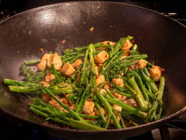 Dökme demir tavalar tavuk, brokoli, acı biber ve aromatik sarımsak gibi lezzetlerle patlar..