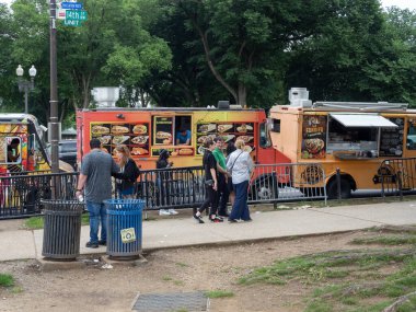 İnsanlar Washington 'da bir dizi yemek kamyonunun yanından rahatça geçiyor..