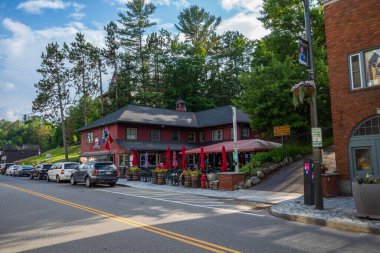 New York 'un kuzeyindeki Lake Placid' de kırmızı bir restoran güneşli bir gökyüzünün altında parlıyor ve bu güzel kasabanın cazibesini ve canlılığını yakalıyor..