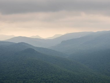 Dağın zirvesinden nefes kesici bir manzara. Van Hoevenberg, Adirondack Dağları 'nın New York, Placid Gölü yakınlarındaki sisli bir sisin içinden katmanlar halinde ortaya çıktığı yer..