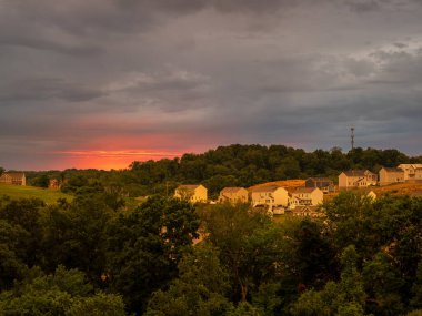 Batan güneşin altın ışıklarıyla yıkanan banliyö halkının nefes kesici manzarası, fırtına bulutları sahneye biraz drama katıyor..