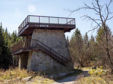 Engebeli bir taş gözetleme kulesi, güneşli bir ormanın ortasında gururla yükseliyor. Spruce Knob, Batı Virginia, ABD 'deki uçsuz bucaksız gökyüzüne bakıyor.