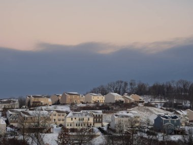 Huzurlu bir Amerikan mahallesi kalın bir kar örtüsünün altında yatarken, kara bulutlar tepemizde belirdi, kış dinginliği ile yaklaşan fırtına arasında çarpıcı bir kontrastlık yarattı..