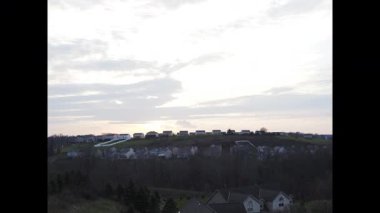 Çarpıcı bir zaman çizelgesi güneşin batışını gösteriyor. Alacakaranlık çökerken bir Amerikan mahallesine altın renkler döküyor..