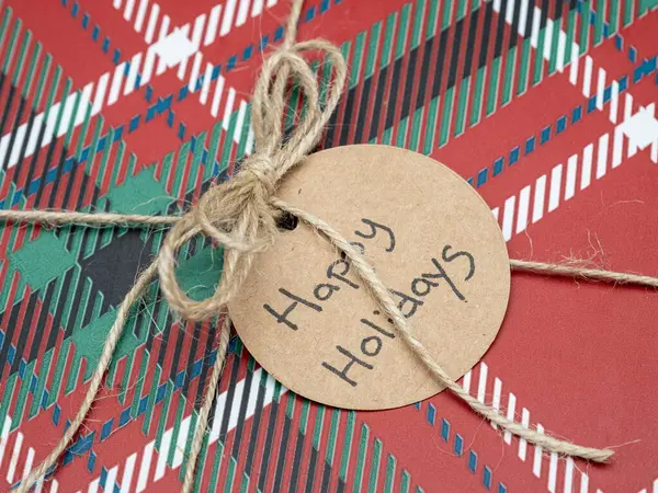 Bayram sezonunun sıcaklığını ve heyecanını yakalayan, kırsal sicimle bağlanmış kırmızı ekoseli şenlikli yakın plan bir fotoğraf..