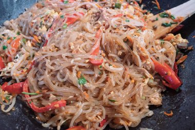 Lezzetli kızarmış cam şehriye, ayrıca selofan erişte olarak da bilinir, renkli sebzeler ve sıcak tavuklu yumuşak tavukla birlikte..