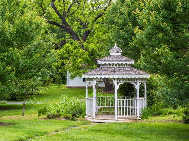 Berryville, Virginia 'daki tarihi Rosemont' ta yemyeşil ağaçların ve çimlerin arasına yerleştirilmiş pitoresk beyaz bir çardak..