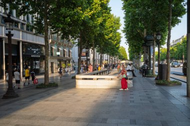 Şanzelize 'nin geniş bir manzarası var. Yürüyen, açık hava kafelerinde oturan insanlar ve klasik Paris mimarisi..