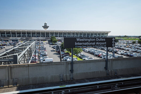 The iconic main terminal of Washington Dulles International Airport overlooks expansive, full parking lots.