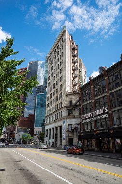 Tarihi tuğla ve modern cam gökdelenlerin karışımı açık ve güneşli bir günde Pittsburgh şehir merkezinde kalabalık bir cadde..