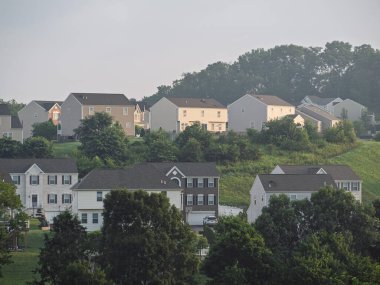Klasik bir Amerikan tarzı ev, Pensilvanya 'da geniş bir gündoğumu gökyüzünün altında, çevresindeki manzaranın olduğu bir tepenin üzerinde durur..