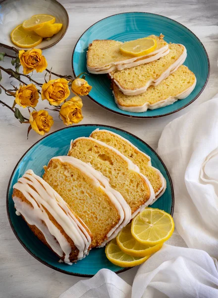 Lemon cake on blue plate with lemons. Delicious fresh homemade dessert. High quality photo