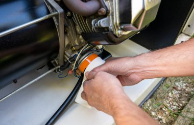 Replacement Maintenance Mechanic Inspecting and replacing engine oil filter using paper towel . High quality photo