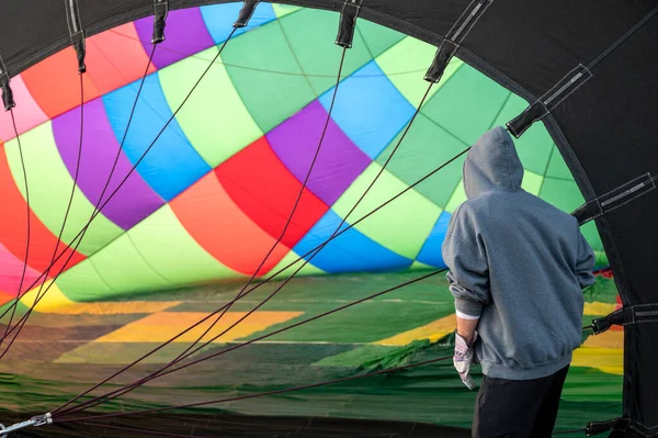カラフルな熱気球の中 冒険のために上空に上昇する気球を準備する者 — ストック写真