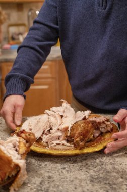 Şükran Günü yemeği. Mutfakta elinde kızarmış hindiyle bekleyen bir adam. Geleneksel yemeğe hazırlanıyorum.