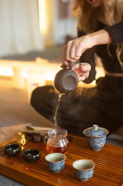 Lotus poz verip çay servisi yapan genç bayan.