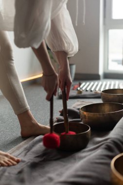 Elinde bir Tibet şarkı kasesinin yakın çekimi. Ekin terapisti Tibet müzik kaseleriyle ses terapisi yapıyor. Spa