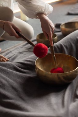 Elinde bir Tibet şarkı kasesinin yakın çekimi. Ekin terapisti Tibet müzik kaseleriyle ses terapisi yapıyor. Spa