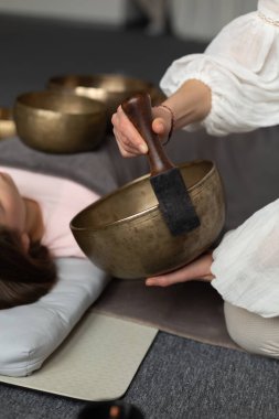 Elinde bir Tibet şarkı kasesinin yakın çekimi. Ekin terapisti Tibet müzik kaseleriyle ses terapisi yapıyor. Spa