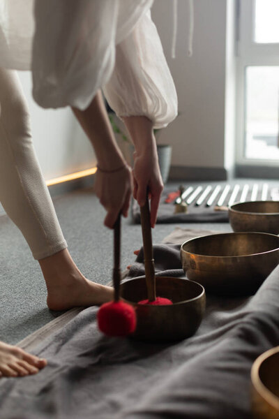 Крупный план Тибетской чаши для пения в твоих руках. Терапевт урожая проводит звукотерапию с помощью тибетских чаш для пения. СПА