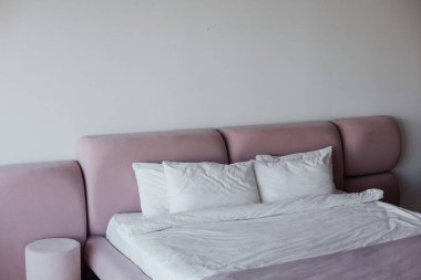 Yatak odasının iç tasarımı beyaz ve pembe pastel renklerde.