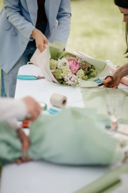 Düğün buketlerini düzenleyen, masaya çiçek saran kadınların ellerini kapat.