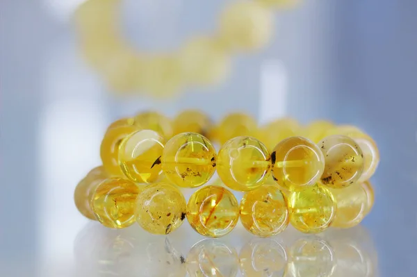 stock image Beautiful amber bracelet on the glass shelf. Close up.