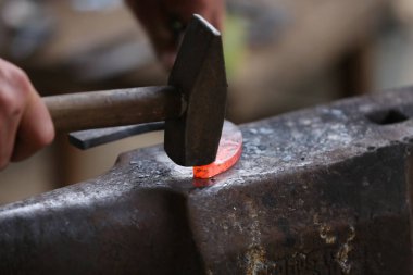  Demirci dövmesi sertleştirme ve ısıtma demiri. Demirci atölyesinde çalışıyor. Smith eski moda bir at nalı yaptı. 