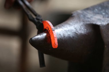  Demirci dövmesi sertleştirme ve ısıtma demiri. Demirci atölyesinde çalışıyor. Smith eski moda bir at nalı yaptı. 