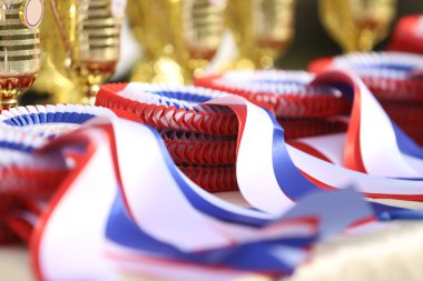 Pile of horse sport trophies rosettes at equestrian event at summertime outdoors